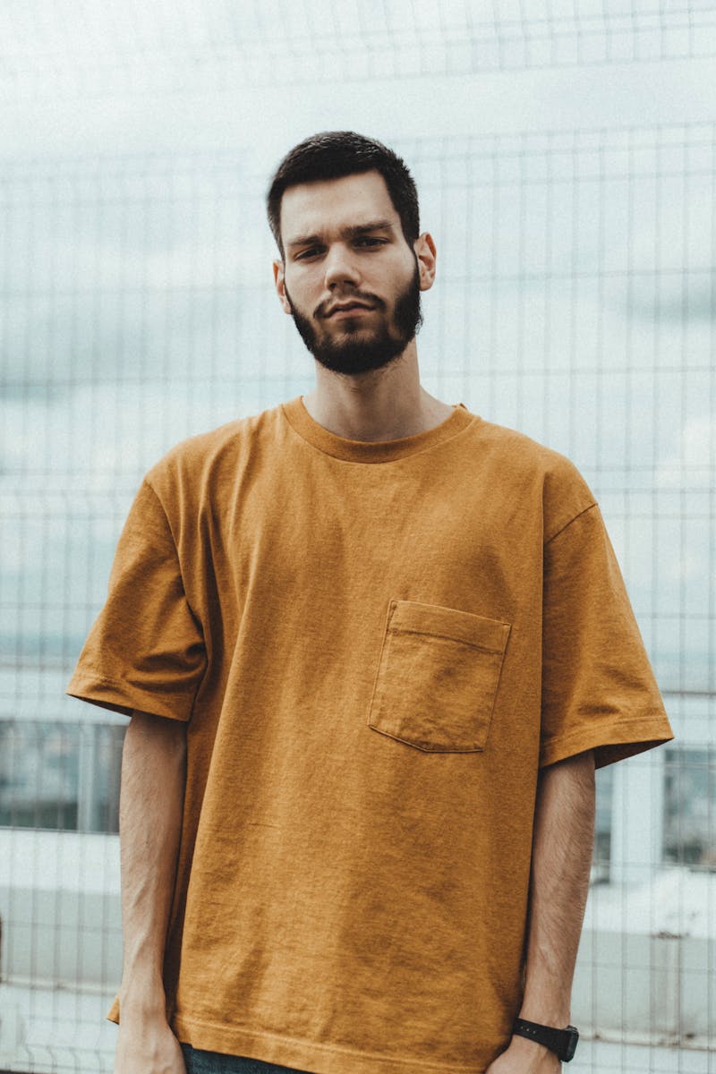 Stylish man in casual wear standing outdoors, showcasing fashion and confidence.